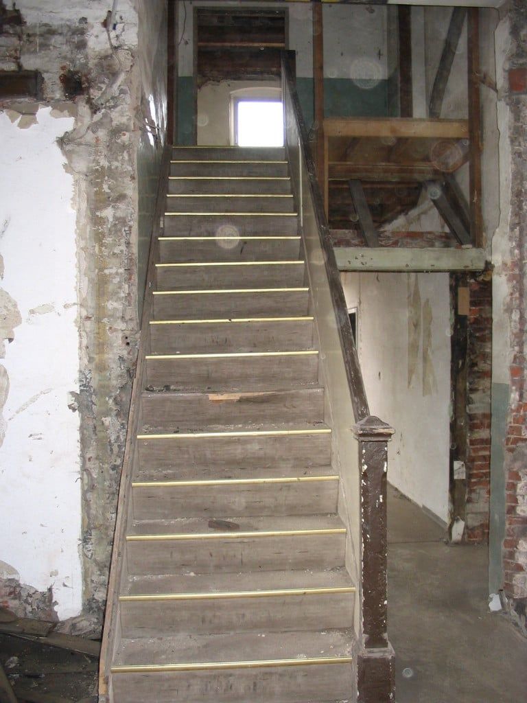 Alte Holztreppe mit Geländer im entkernten Treppenhaus