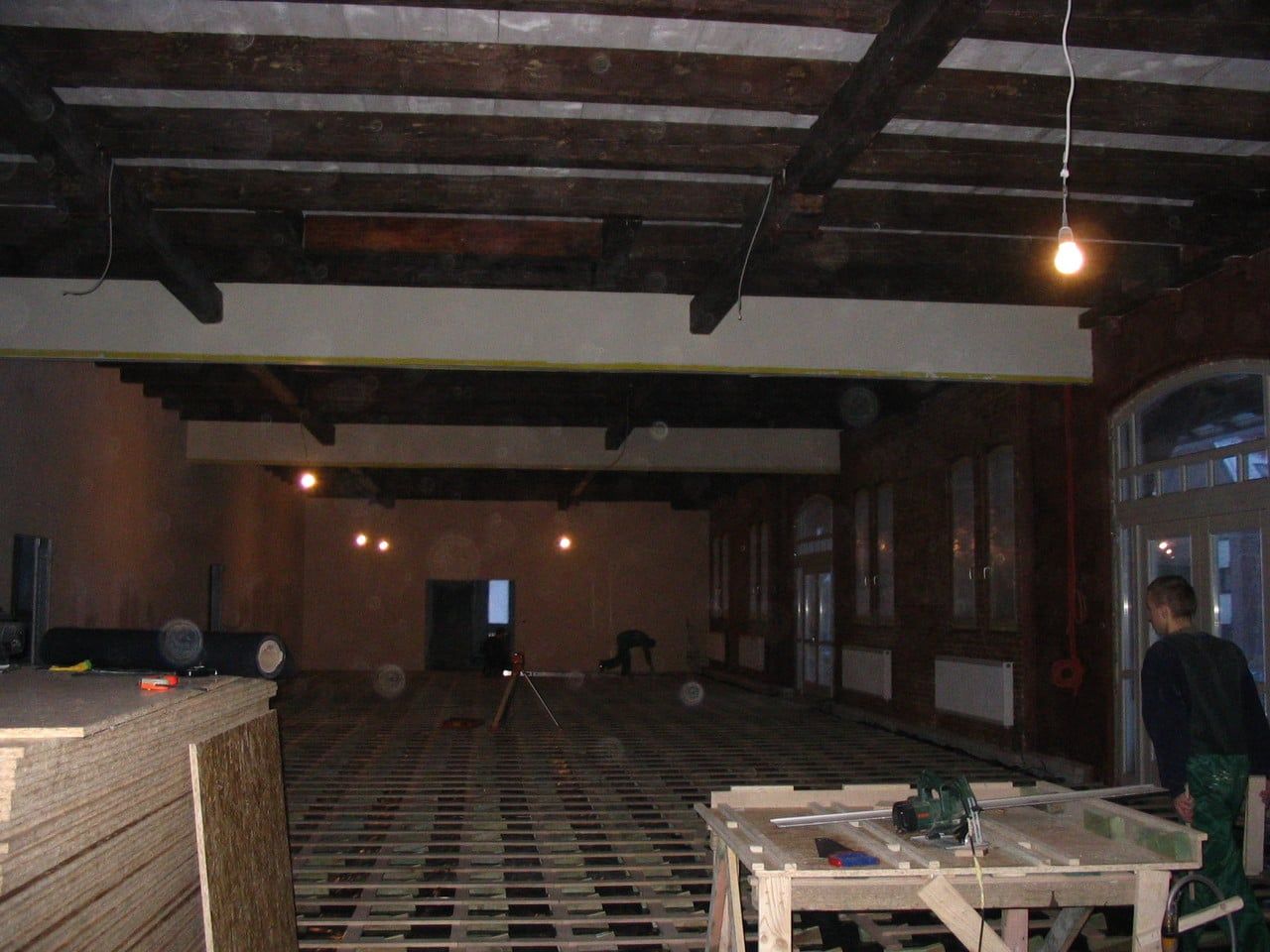 Saal mit Holzbalkendecke im Bau, Lattenunterboden und Arbeitstisch