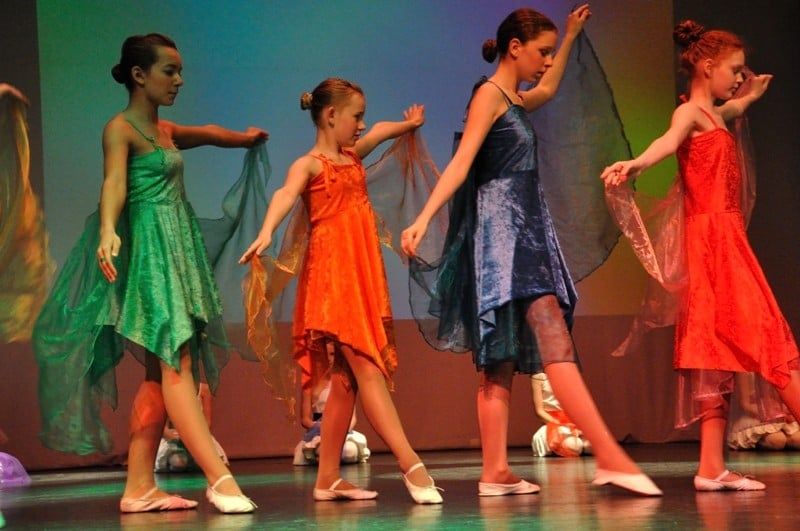 Vier Tänzerinnen in grünem, orangefarbenem, blauem und rotem Kleid mit Schleiern auf der Bühne