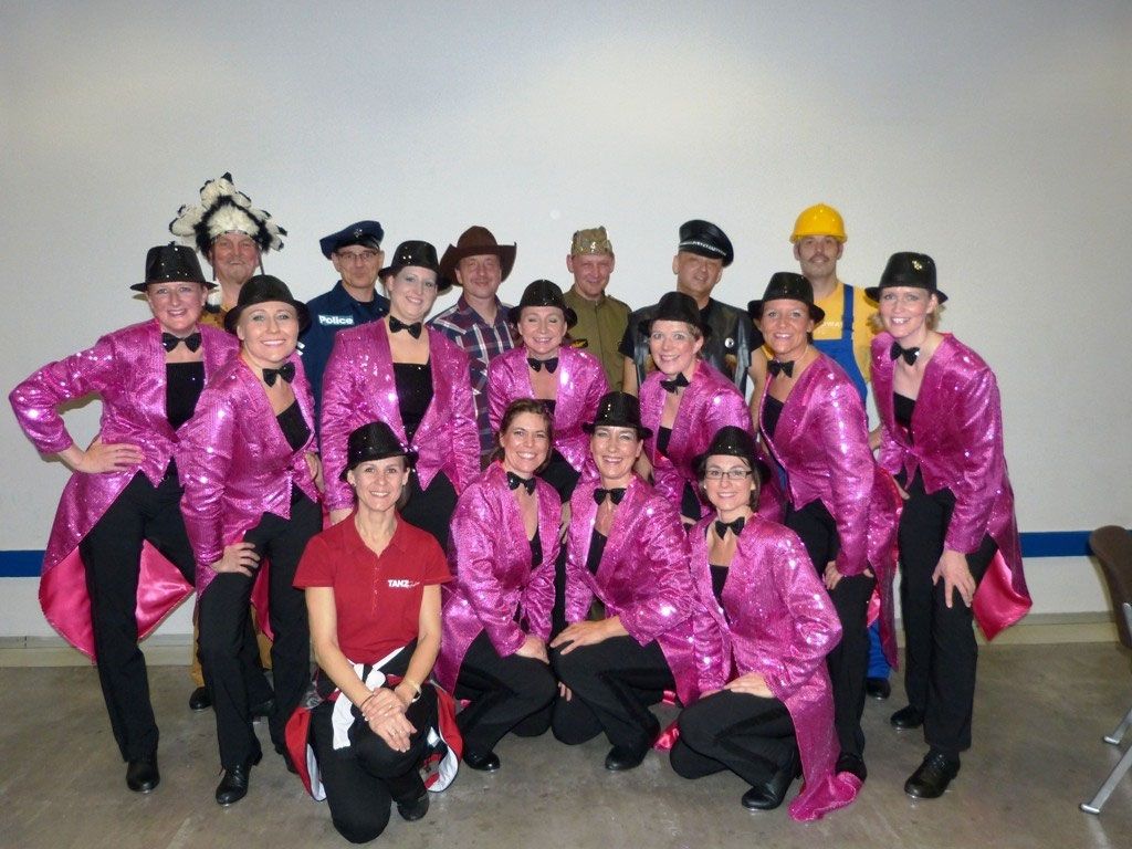 Gruppenfoto der Steptänzerinnen und Steptänzer in pinken Fracks und Kostümen