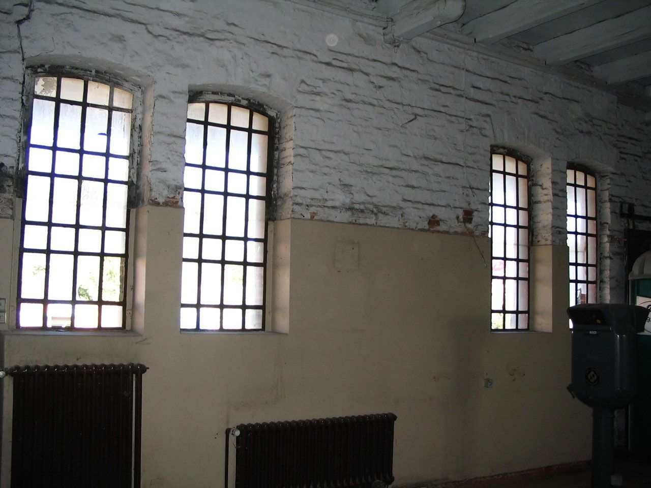 Weiße Halle mit Sprossenfenstern vor dem Umbau