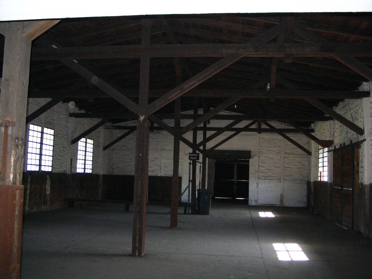 Dunkle Lagerhalle mit Holzstützen und Sprossenfenstern