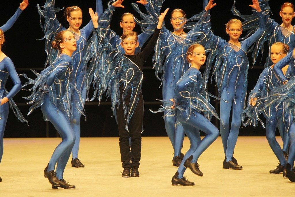Tänzerinnen und Tänzer in blauen Kostümen mit Fransen beim Steptanz