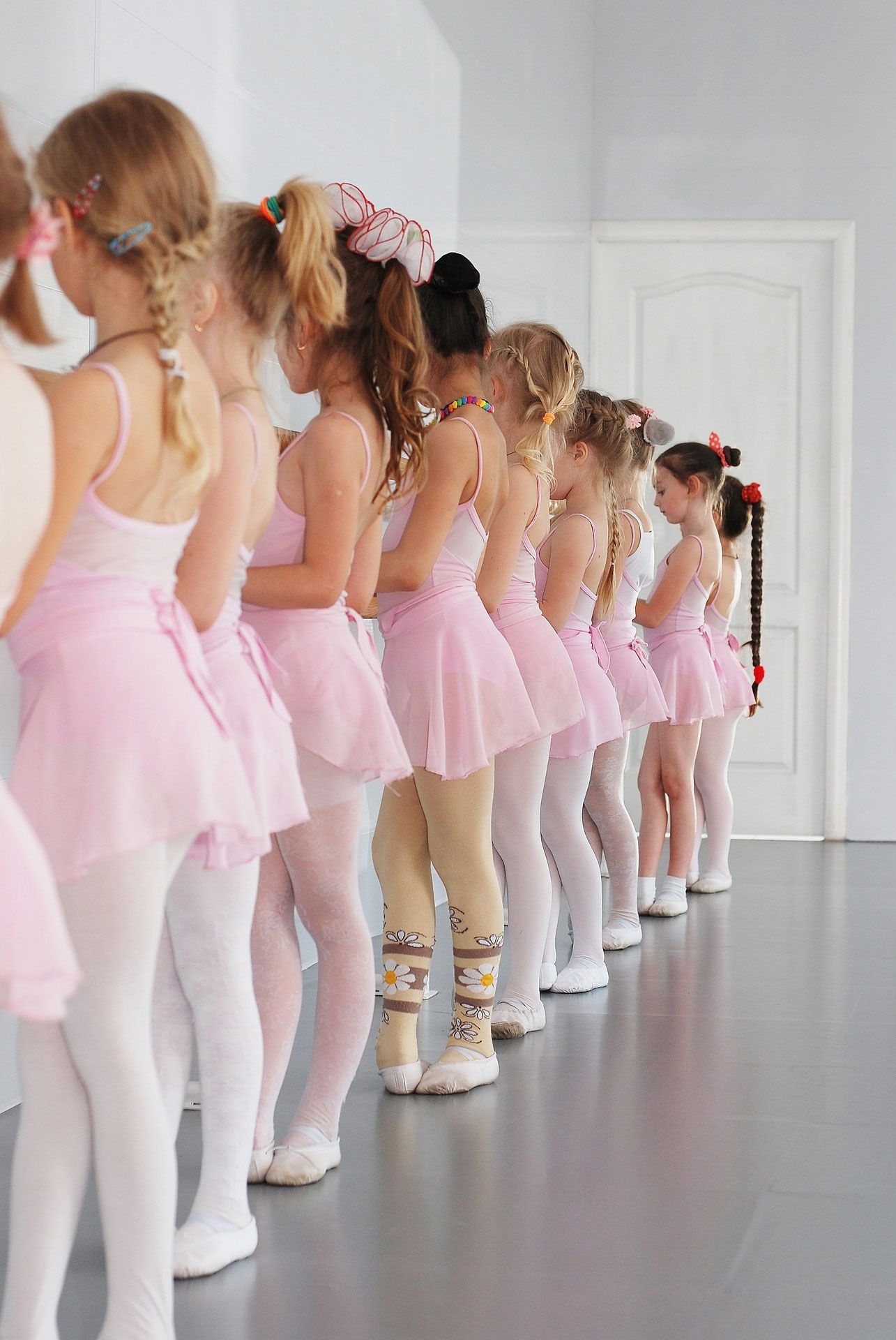 Kinder in rosa Ballettkleidung stehen in einer Reihe an der Stange