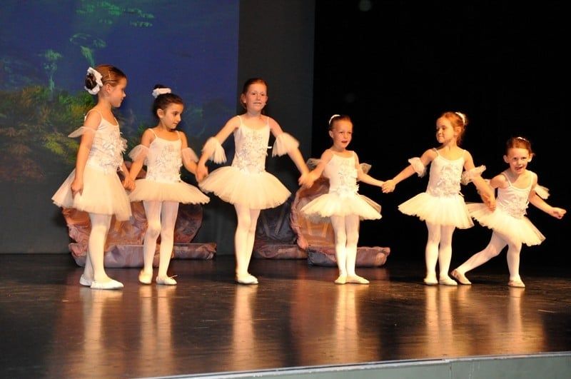 Sechs kleine Mädchen in Tutus in einer Reihe auf der Bühne