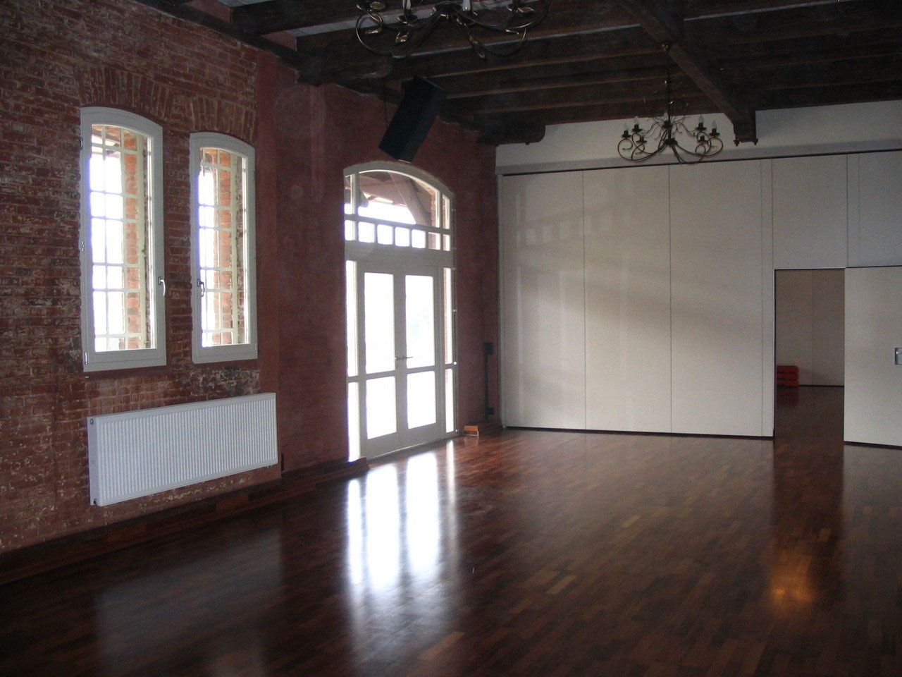 Tanzsaal mit Rundbogenfenstern in der Backsteinwand
