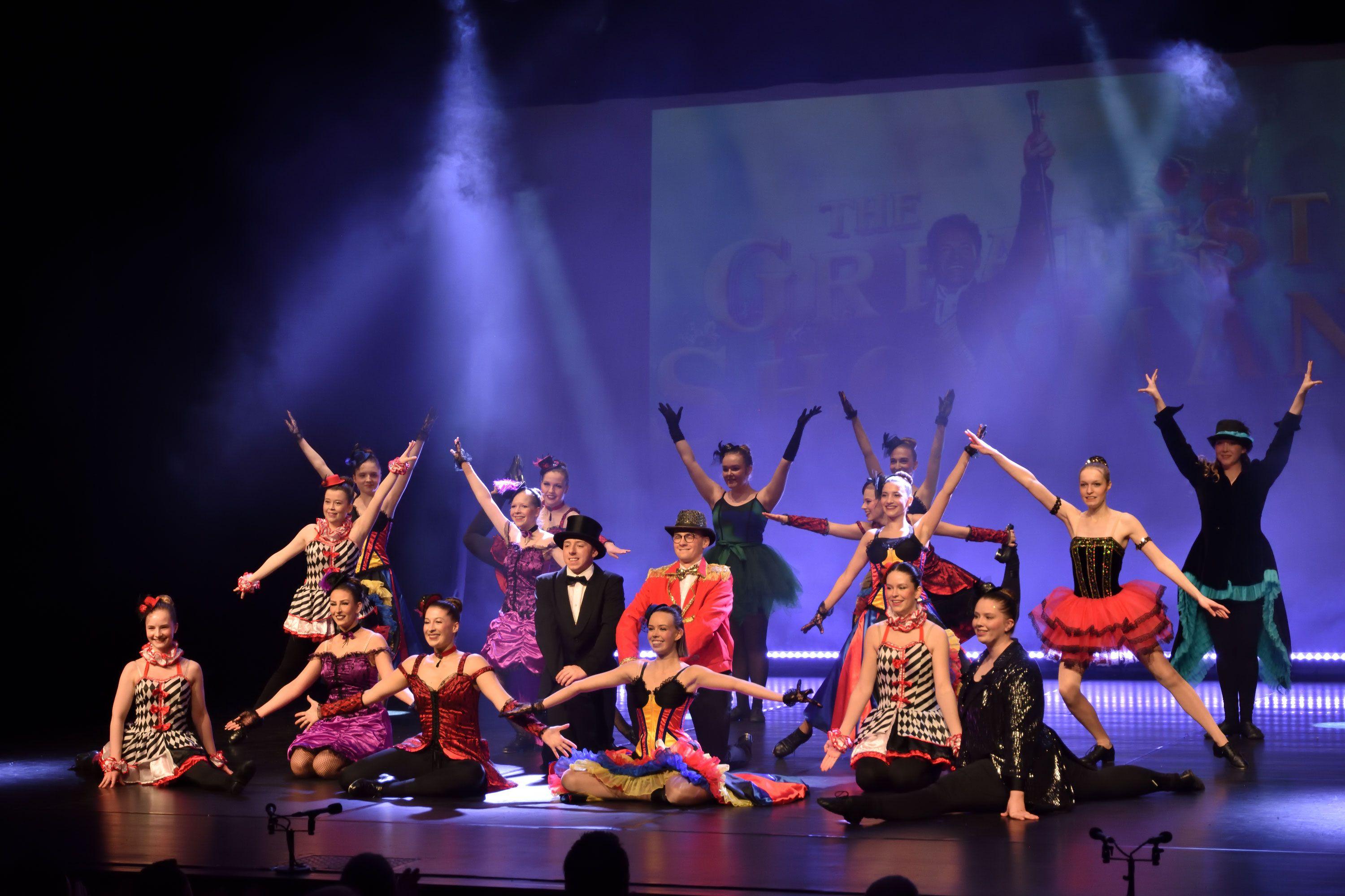 Große Showgruppe in bunten Kostümen beim Finale einer Tanzshow