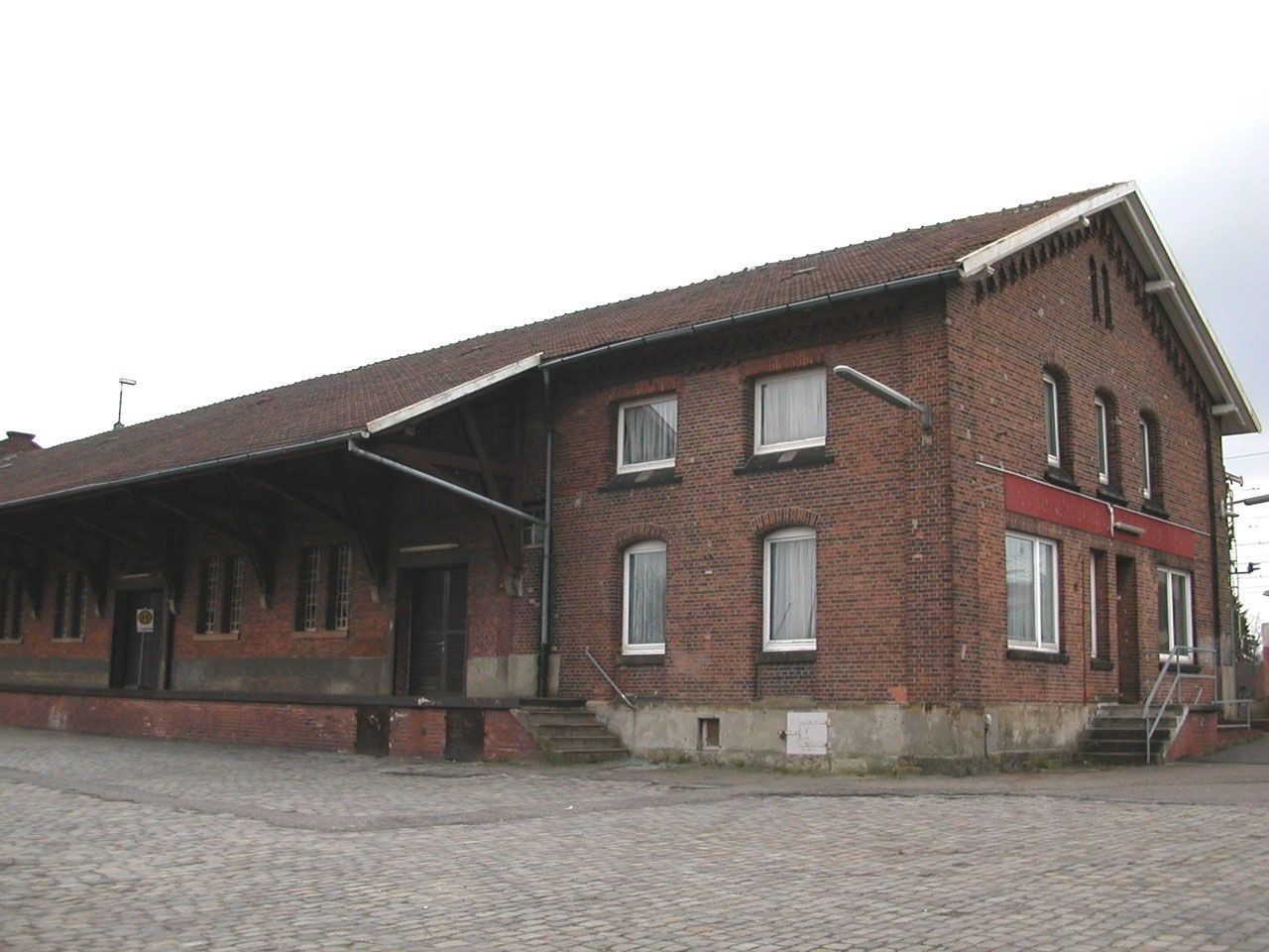Backsteinfassade der leerstehenden Güterabfertigung unter grauem Himmel