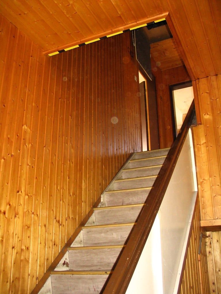 Holztreppe in einem holzverkleideten Treppenhaus